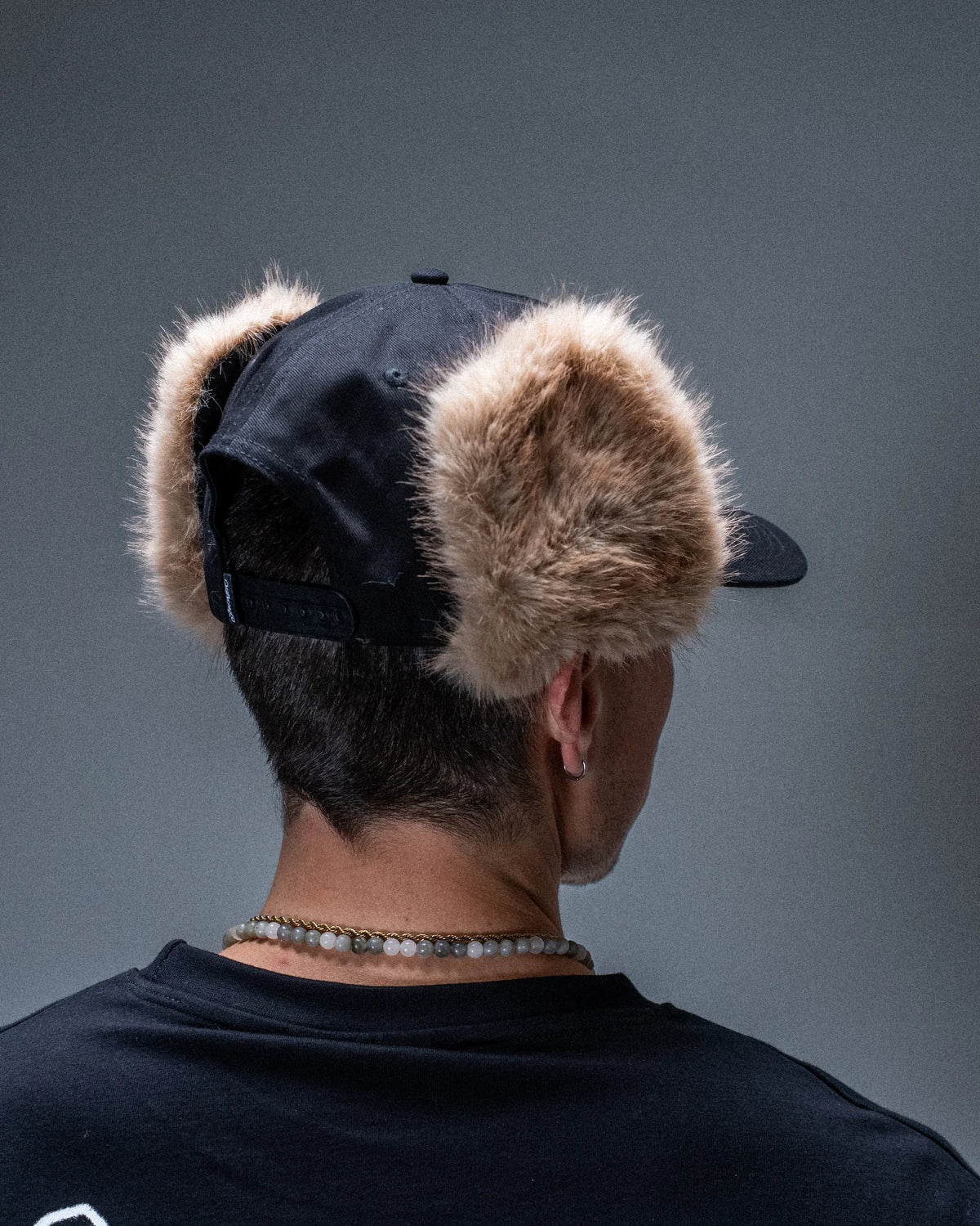 Casquette Jacker Flap Ear Snapback noire — produit porté de dos